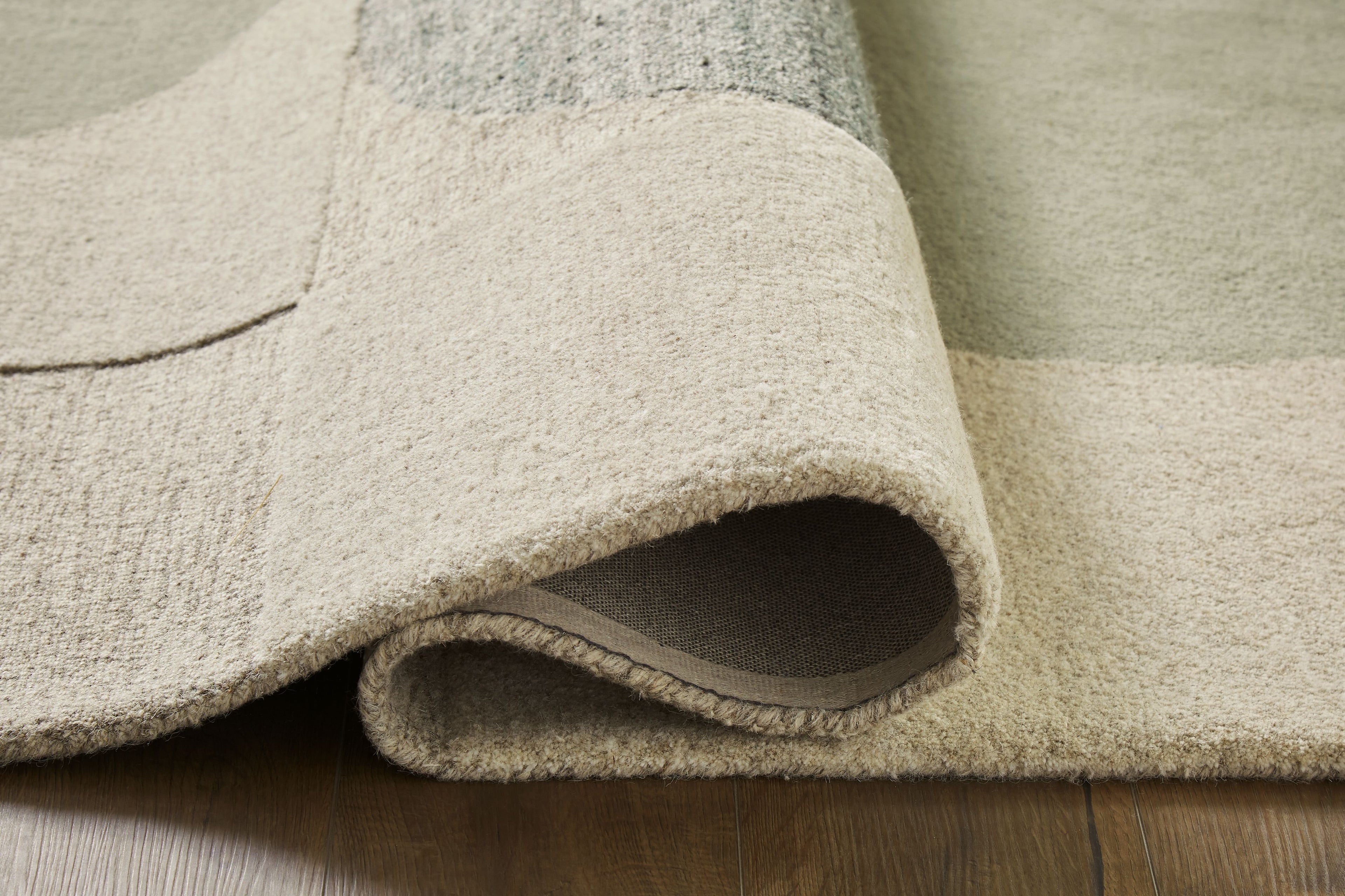 Beige rug pile with rolled edge and textured underside