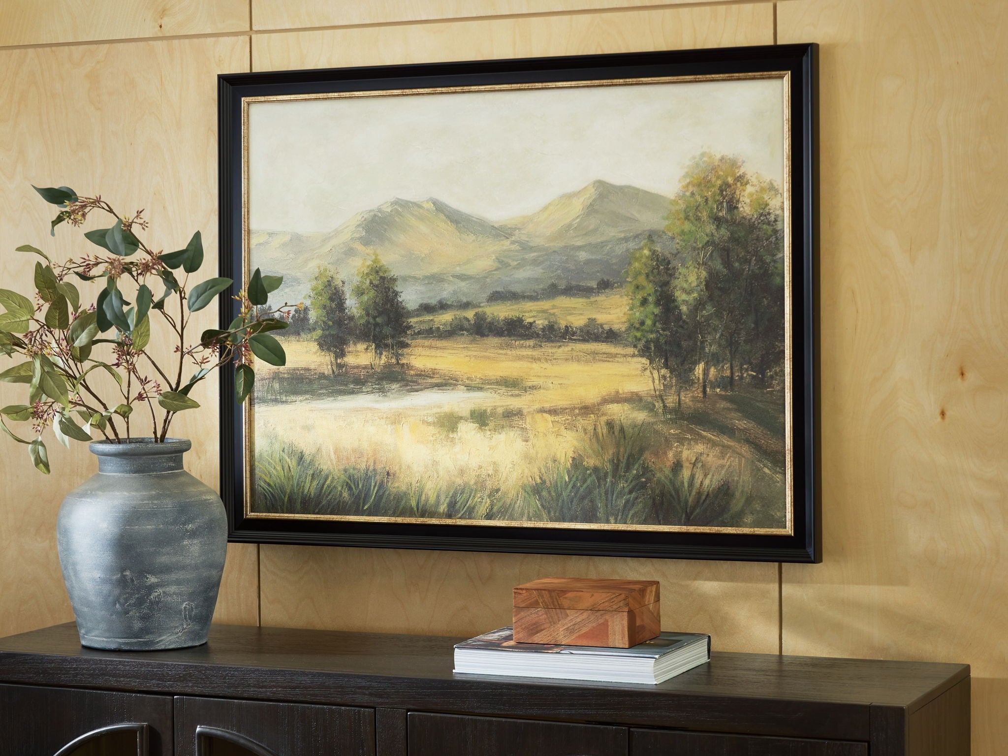 Framed landscape wall art with mountains, meadow, and trees; dark frame with mat.