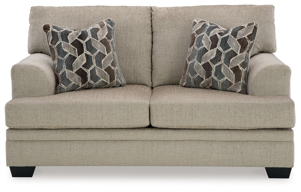 Light beige fabric loveseat with two geometric patterned pillows, head-on view