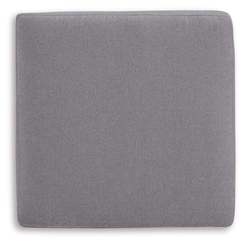 Gray fabric accent ottoman with square back panel and rounded top cushion.