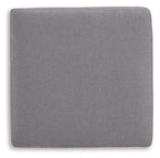 Gray fabric accent ottoman with square back panel and rounded top cushion.