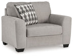 Gray upholstered armchair with patterned throw pillow