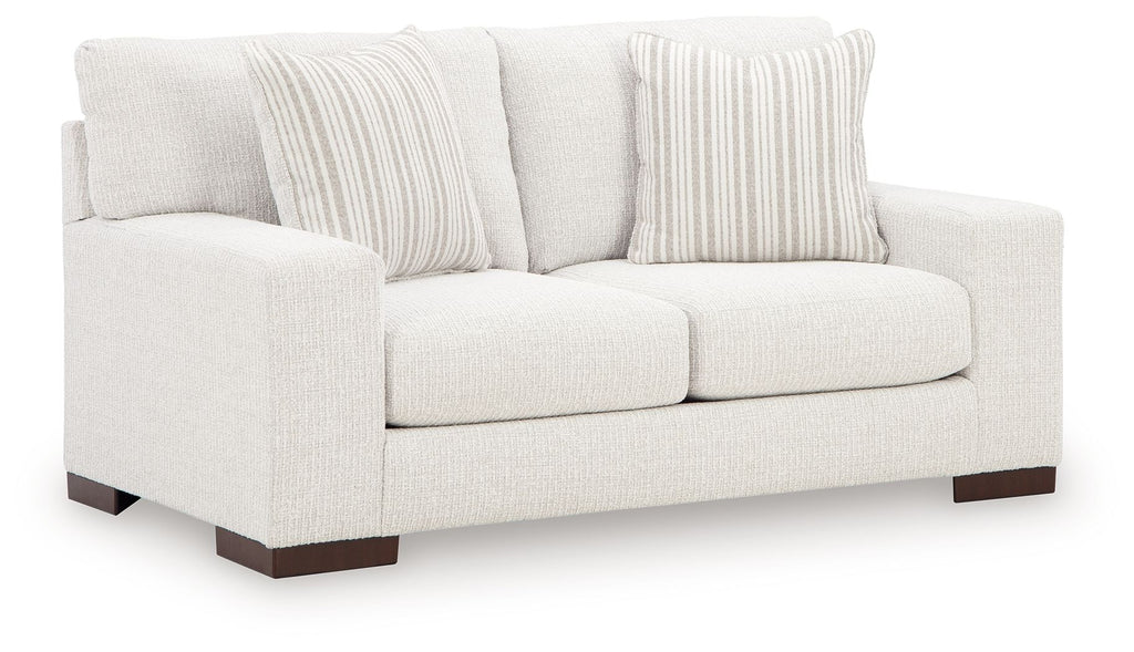 Frosted white loveseat with two front cushions, dark legs, and striped throw pillows