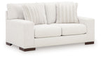 Frosted white loveseat with two front cushions, dark legs, and striped throw pillows