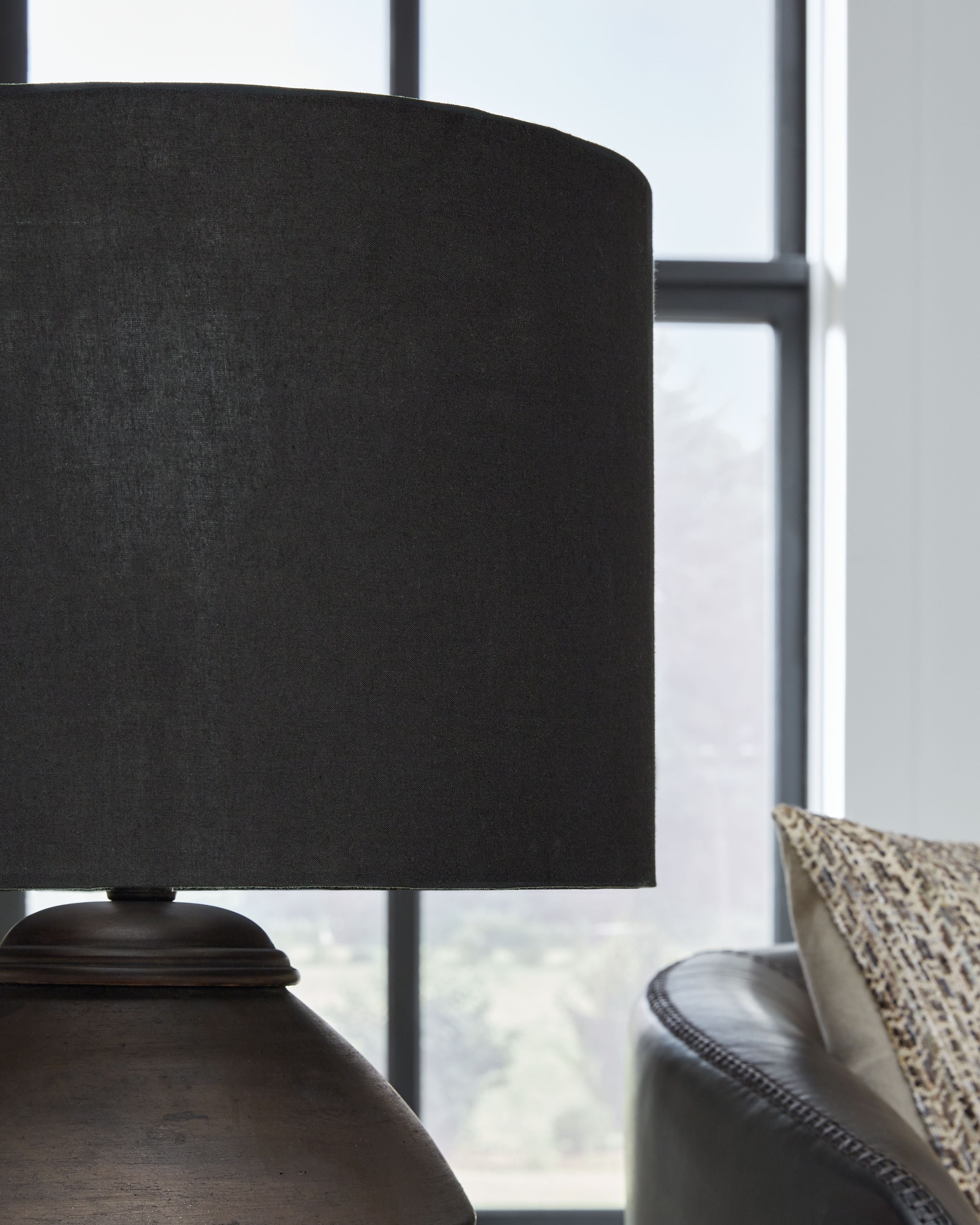 Table lamp with black fabric shade over dark bronze base, side view