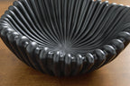 Black ribbed bowl with stacked scallops, close-up interior