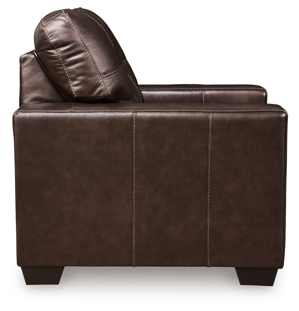 Dark brown leather accent chair side view with curved back cushion