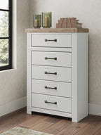 White chest of drawers with five drawers and brown top, dark bar handles