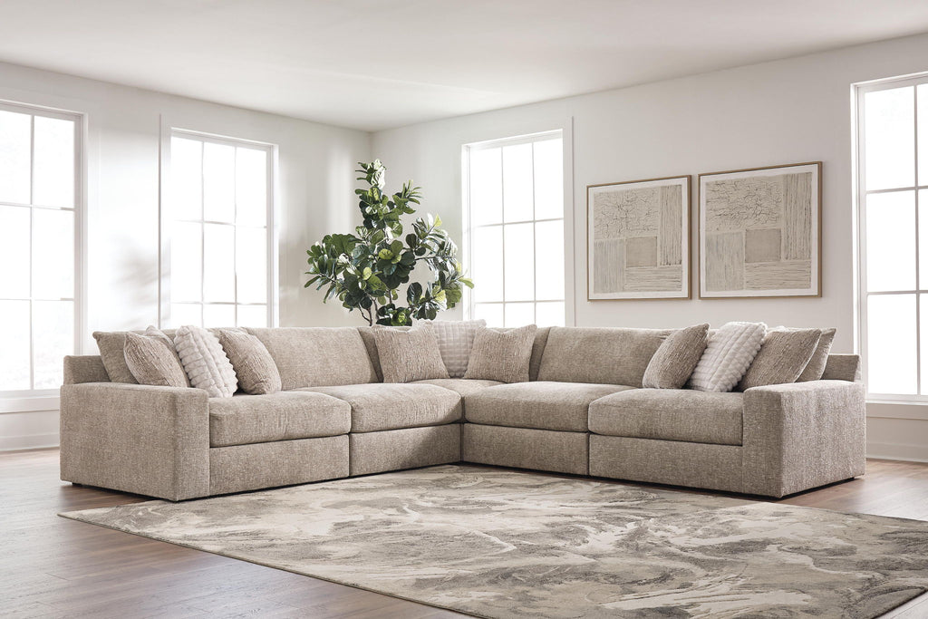 Burlap-upholstered sectional sofa corner with chaise seats and stacked throw pillows