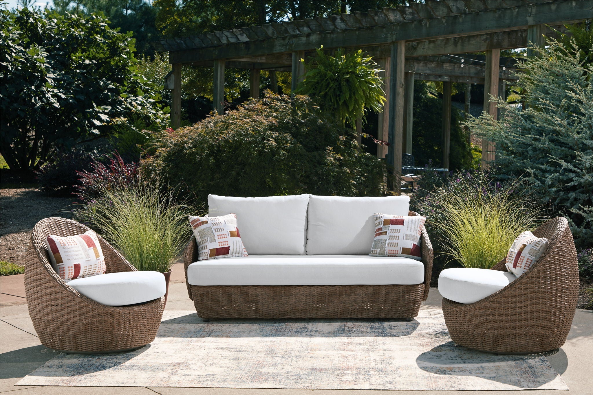 Outdoor furniture set: loveseat and two swivel chairs with beige wicker and white cushions