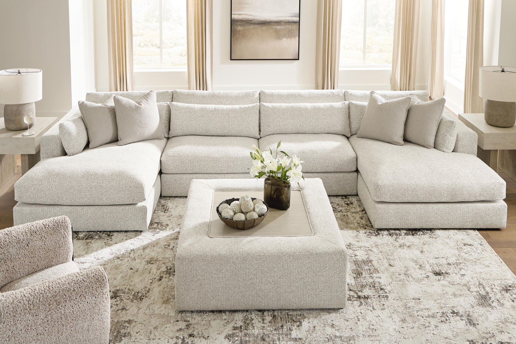 Beige sectional sofa with corner chaise section, throw pillows, and tufted seat cushions