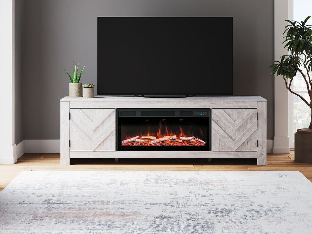 Light wood fireplace TV stand with open media shelf and burning fireplace insert