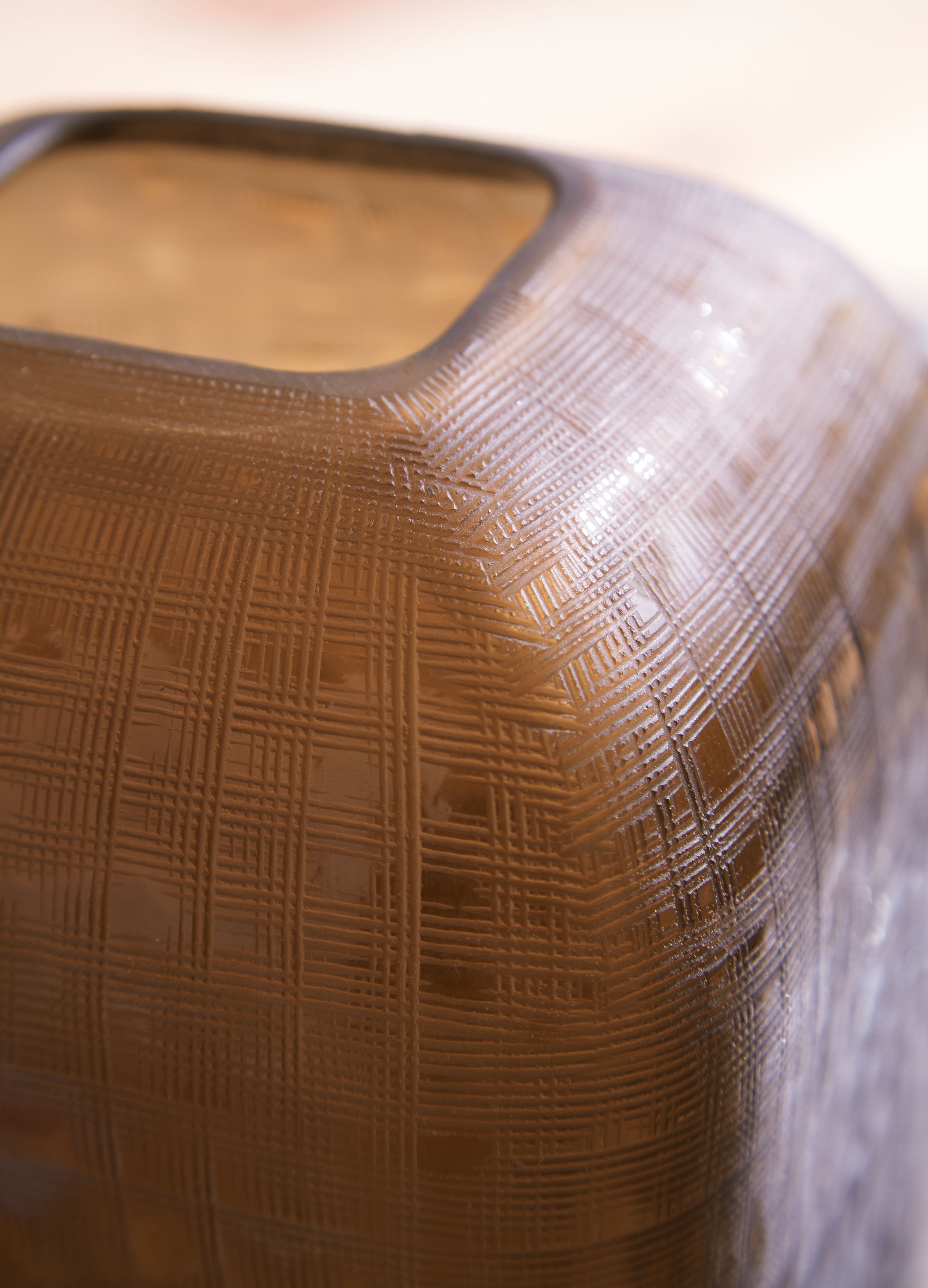 Dark brown vase close-up with basket-weave texture and open rim edge