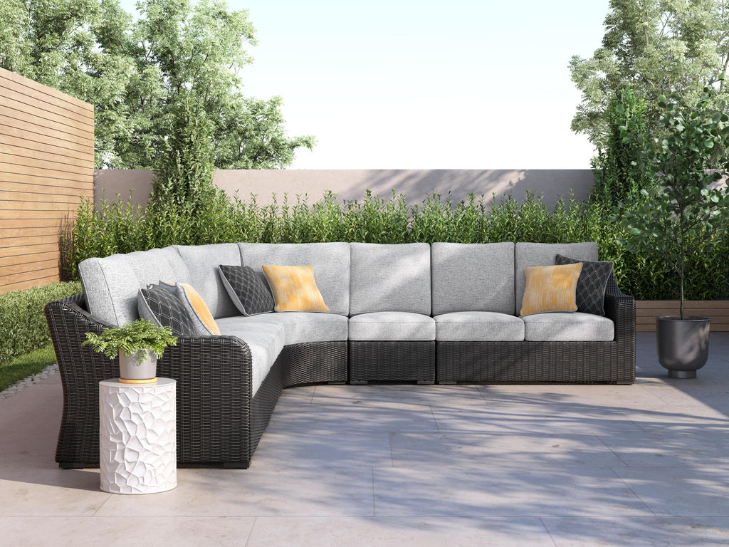 L-shaped outdoor sectional sofa with gray cushions, black armrests, yellow pillows