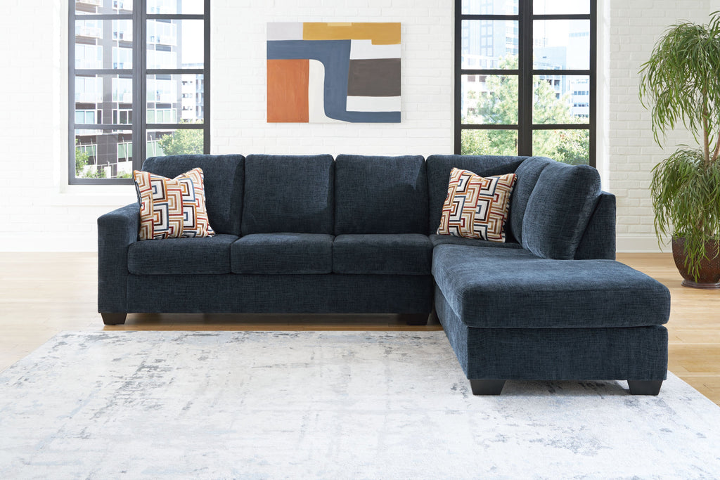 Dark navy sectional sofa with chaise and geometric throw pillow accents