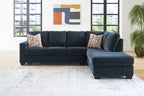 Dark navy sectional sofa with chaise and geometric throw pillow accents
