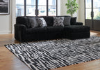 Black corduroy sectional sofa with chaise arm and tufted seat cushions