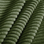 Green corduroy-style sofa upholstery close-up with ribbed texture