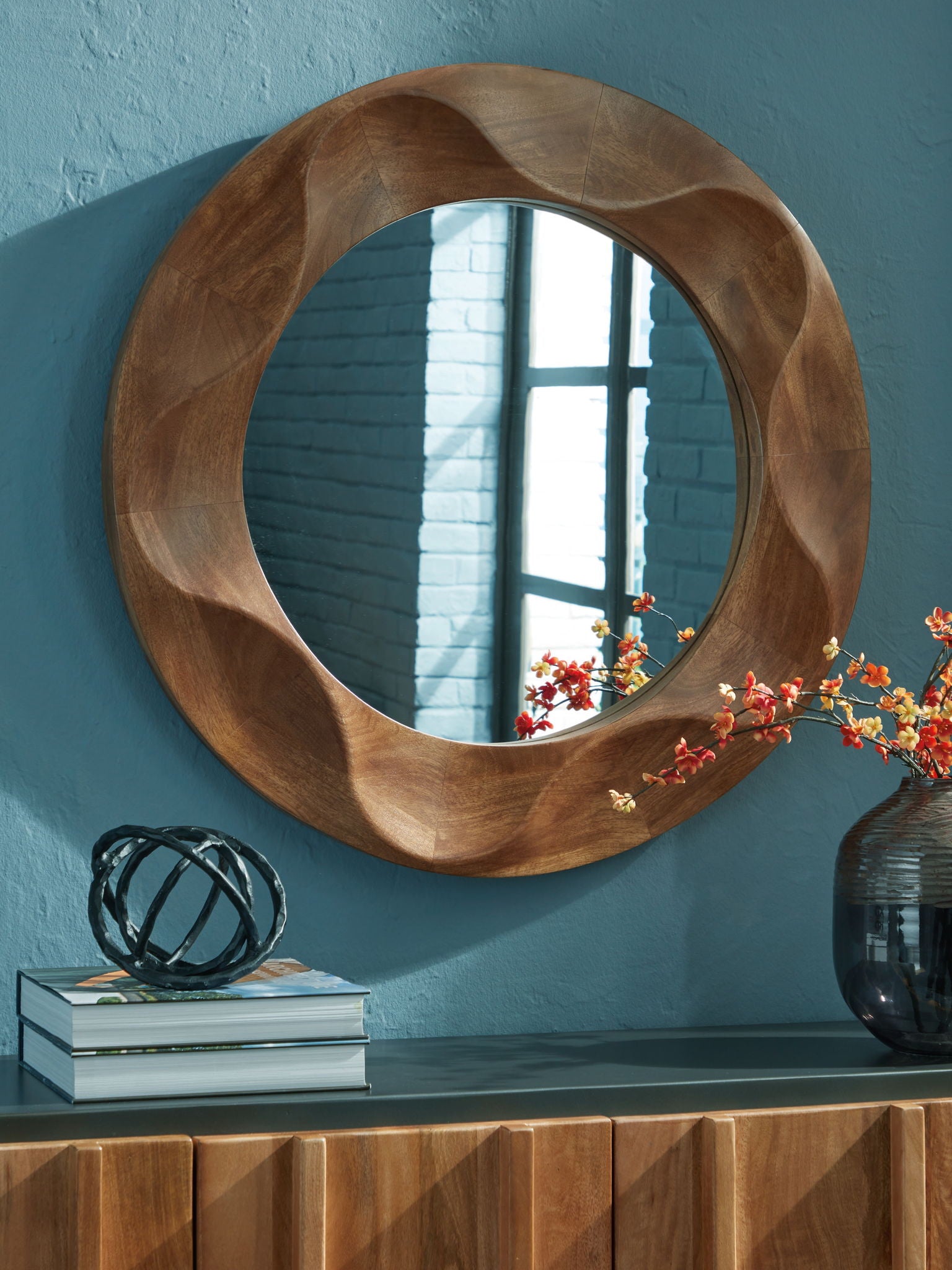 Brown round accent mirror with wavy wood frame and reflective glass center