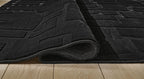 Washable rug close-up, black brick-pattern texture with rolled edge