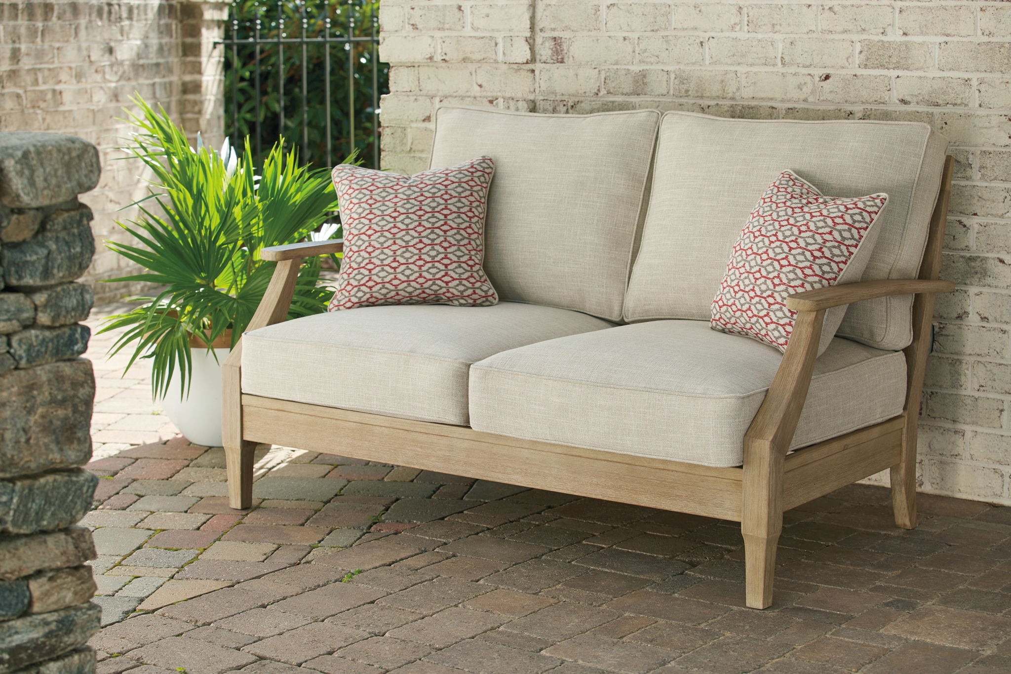 Beige lounge sofa with two back pillows and solid seat cushions on wood frame
