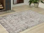 Distressed geometric area rug with light off-white base and gray motifs on floor