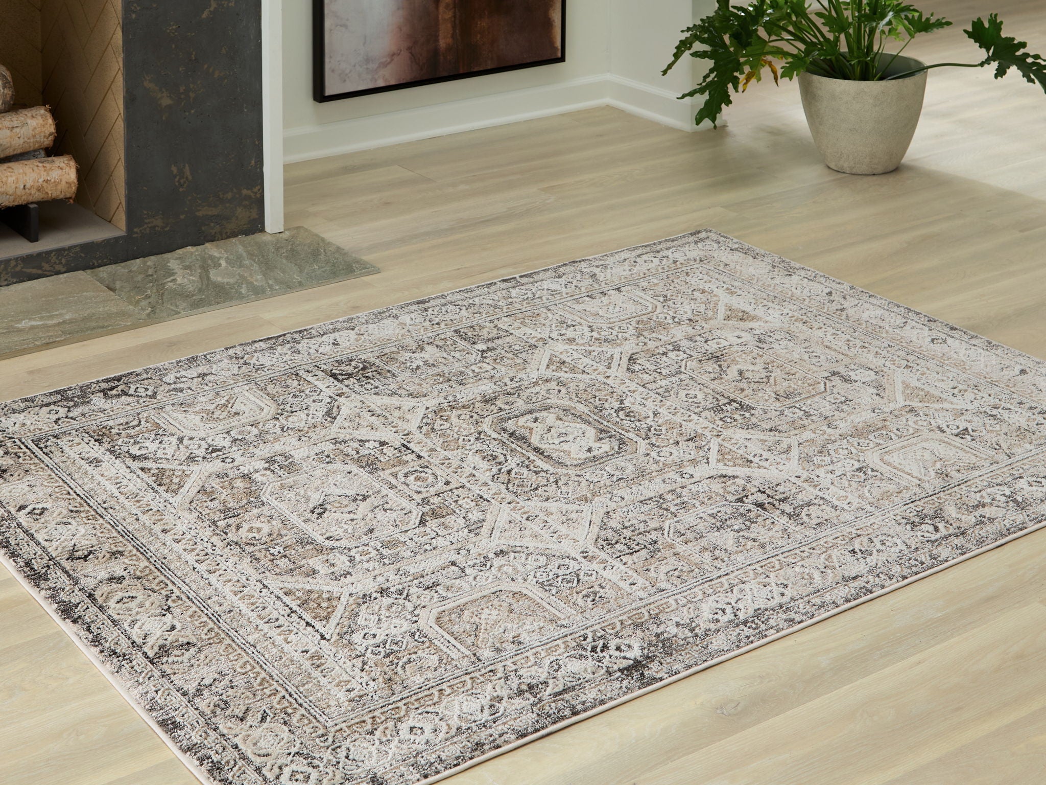 Distressed geometric area rug with light off-white base and gray motifs on floor