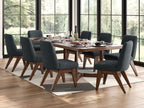 Dining table set in dark brown with six dark gray upholstered chairs by window