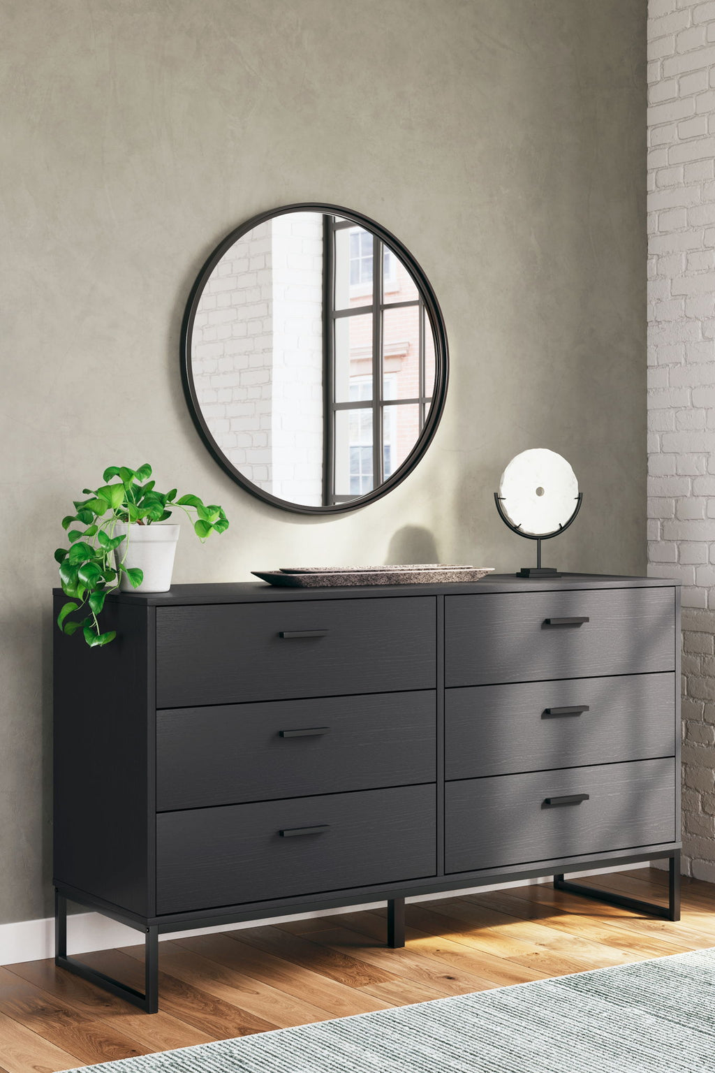 Black bedroom dresser with drawers and round mirror