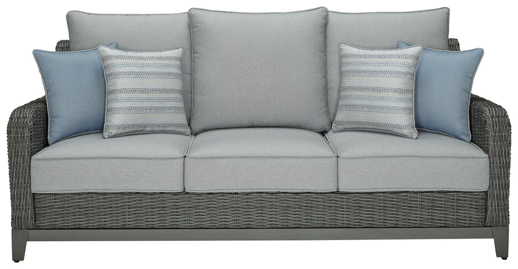 Gray woven outdoor sofa with three seat cushions and blue throw pillows