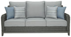 Gray woven outdoor sofa with three seat cushions and blue throw pillows
