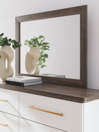 Rectangular bedroom mirror with dark brown wood frame and ledge on dresser top