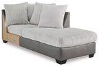 Corner chaise lounge with ribbed light gray fabric seat, two pillows, dark base