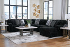 Black corduroy sectional sofa with chaise corner and patterned throw pillows