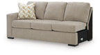 Stone-beige fabric sofa with patterned throw pillow, upholstered seat cushions, black legs