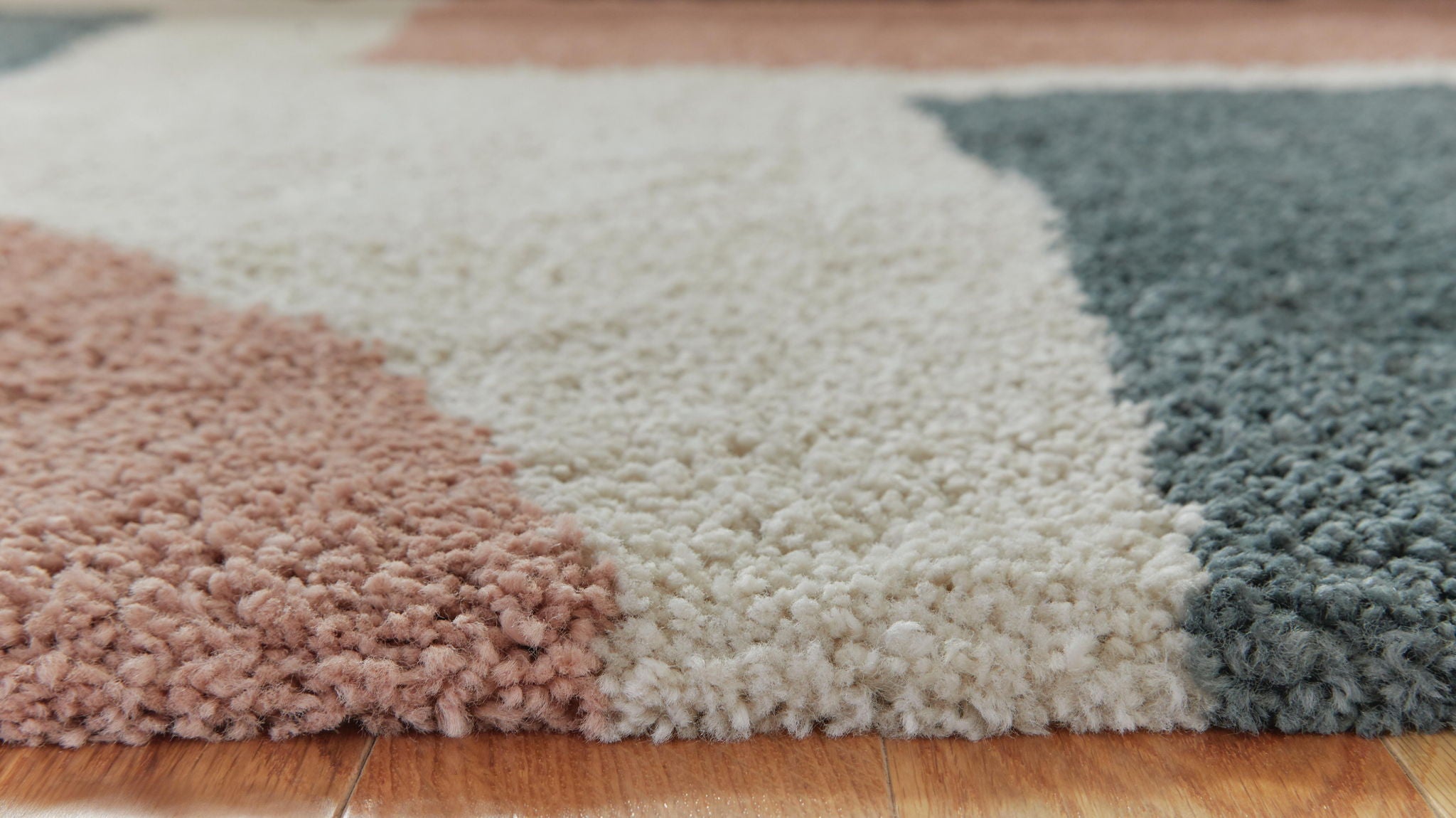 Pink, cream, and teal shag rug with geometric blocks