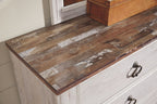 Five-drawer chest close-up with distressed wood top and dark metal knob pulls