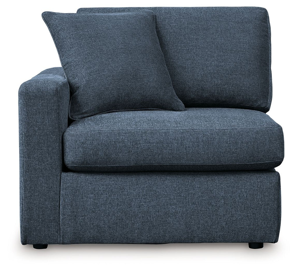 Ink blue fabric corner chair with thick seat cushion and two large back pillows.