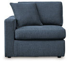 Ink blue fabric corner chair with thick seat cushion and two large back pillows.