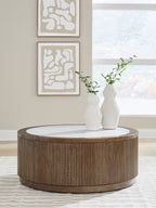 Round side table with slatted wood sides and gray round top, with a white vase.