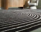 Eldonmore rug with white wavy contour lines on dark black pile.