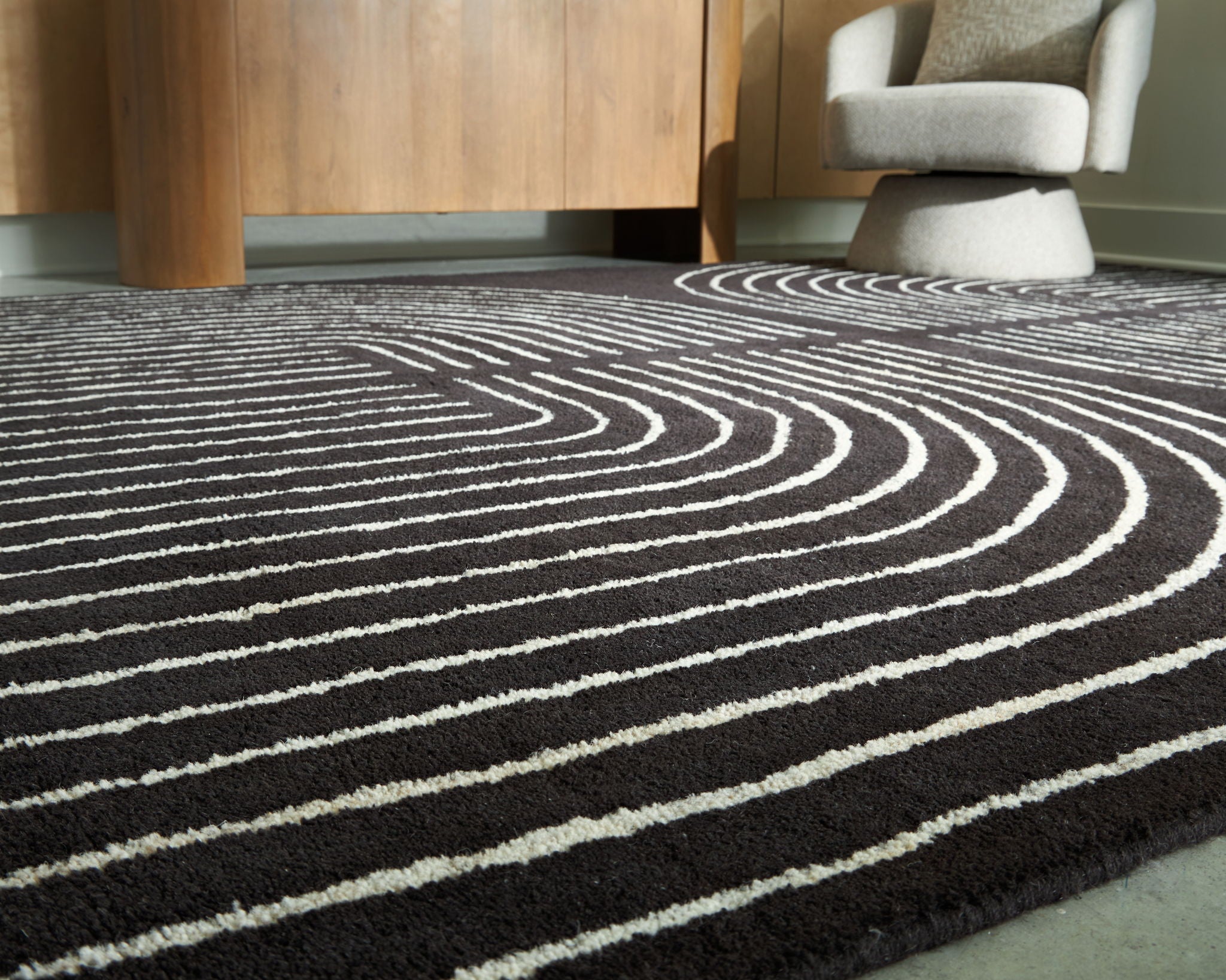Eldonmore rug with white wavy contour lines on dark black pile.