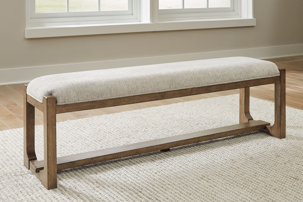 Upholstered dining bench, oatmeal seat with light brown frame and low shelf, angled view