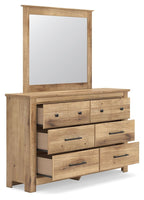 Light brown dresser with six drawers and bar pulls, mirror leaning on top