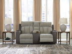 Power reclining loveseat with adjustable headrests, light textured upholstery, padded armrests