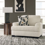 Quartz chair and a half armchair in light beige upholstery with patterned lumbar pillow