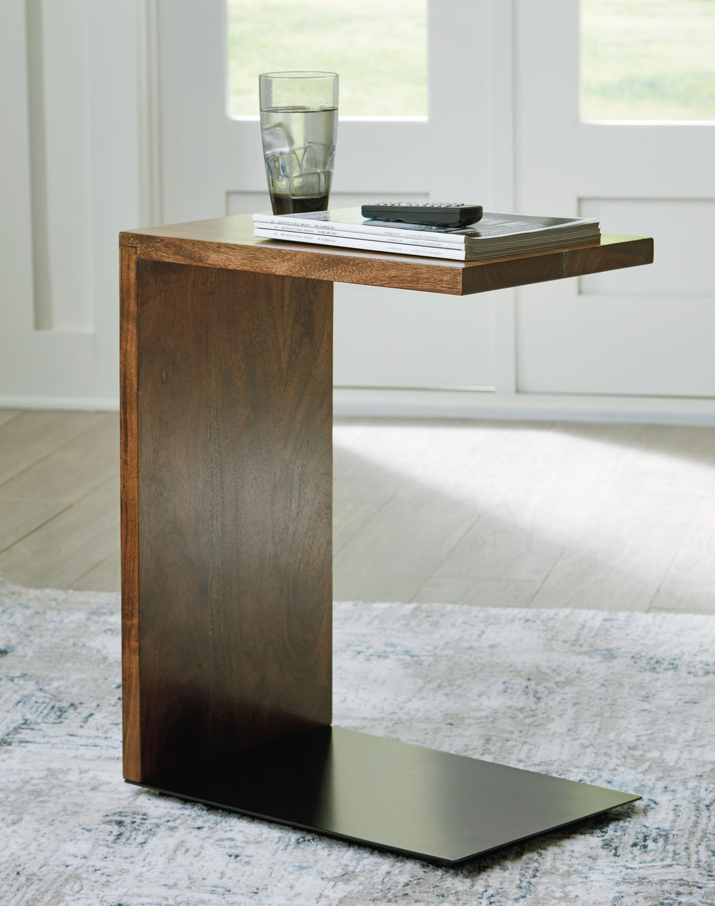 Brown wood accent table with dark base plate and wide tabletop for decor.