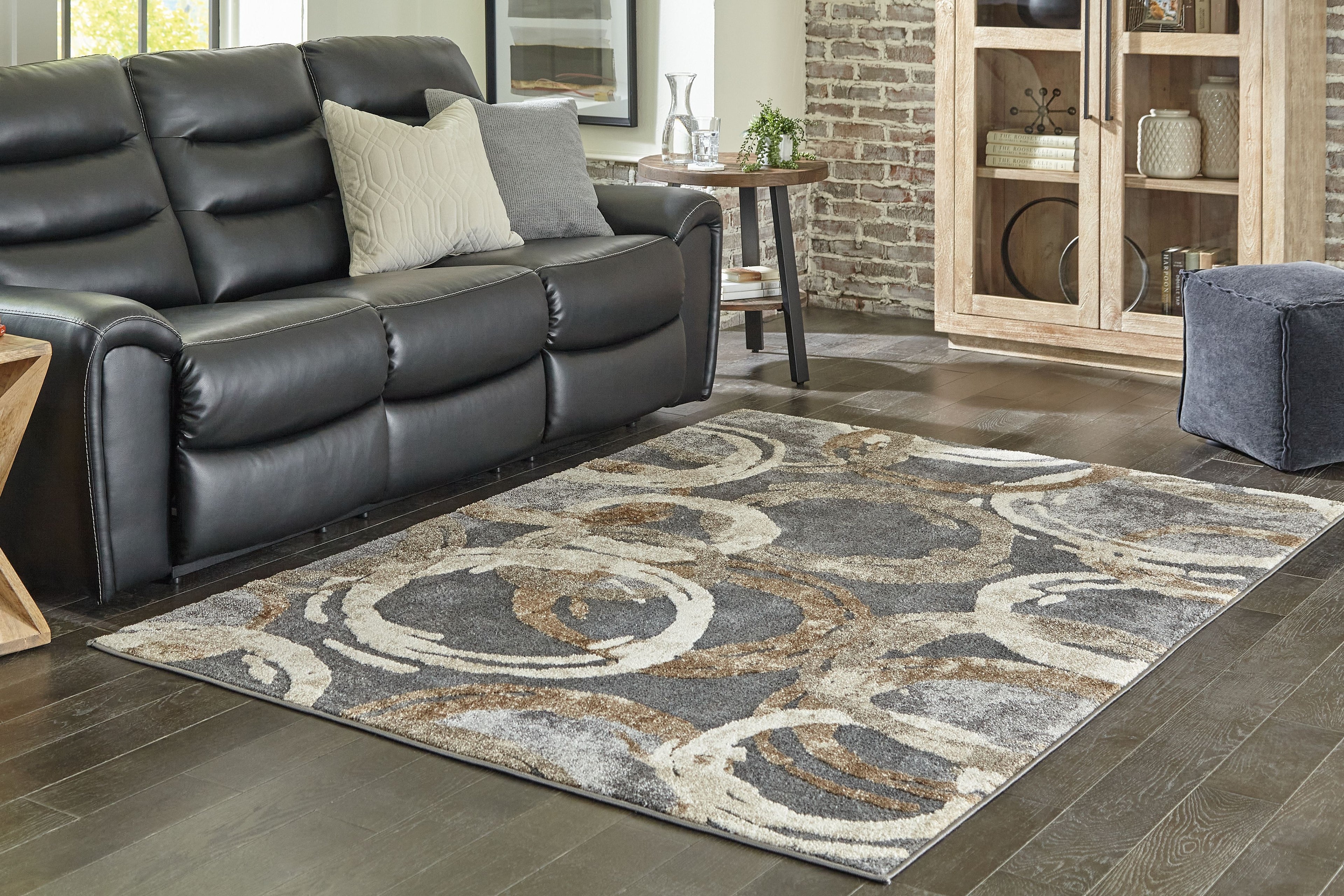 Faelyn area rug with dark gray, cream, and tan abstract swirl pattern with border
