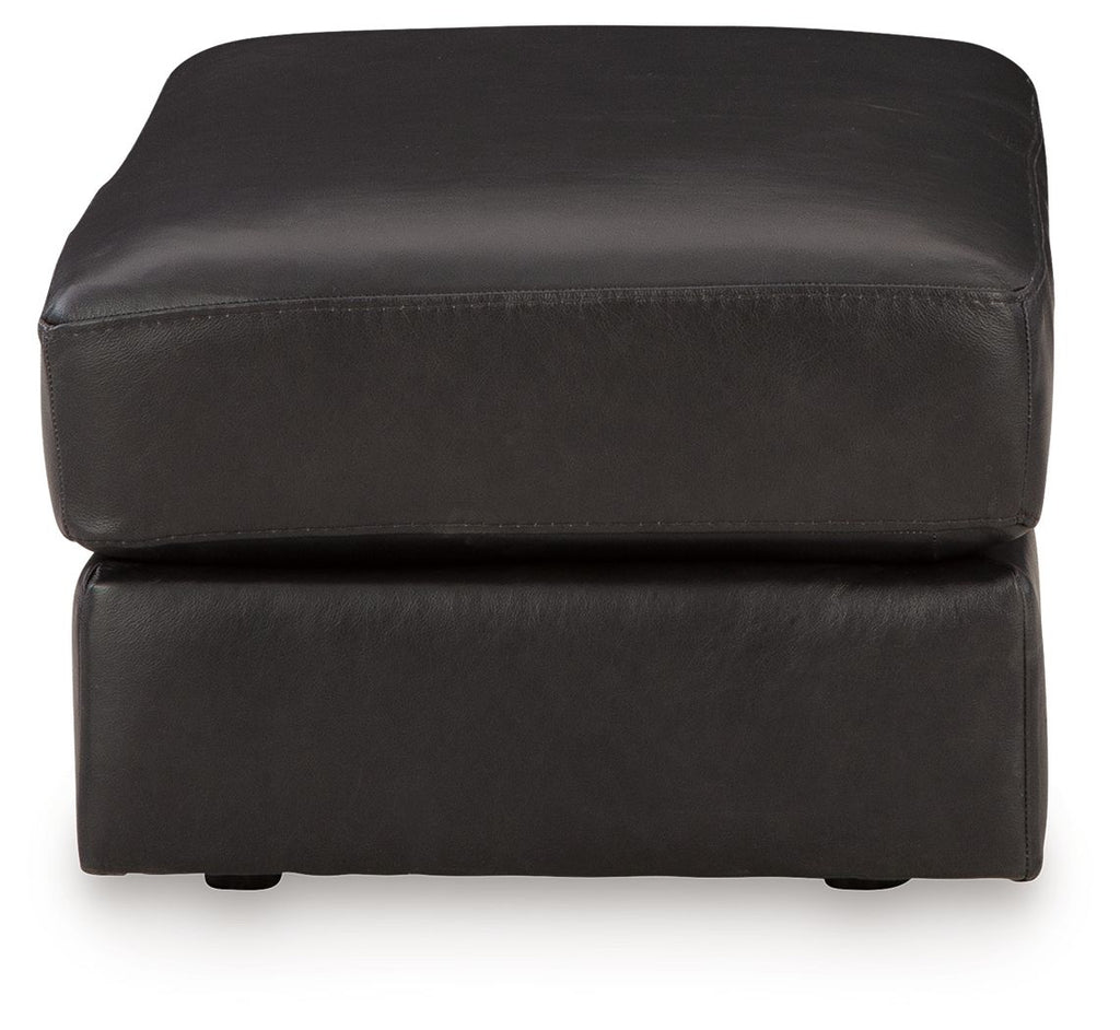 Onyx leather ottoman with rounded corners, padded top, and short legs