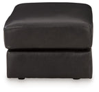 Onyx leather ottoman with rounded corners, padded top, and short legs
